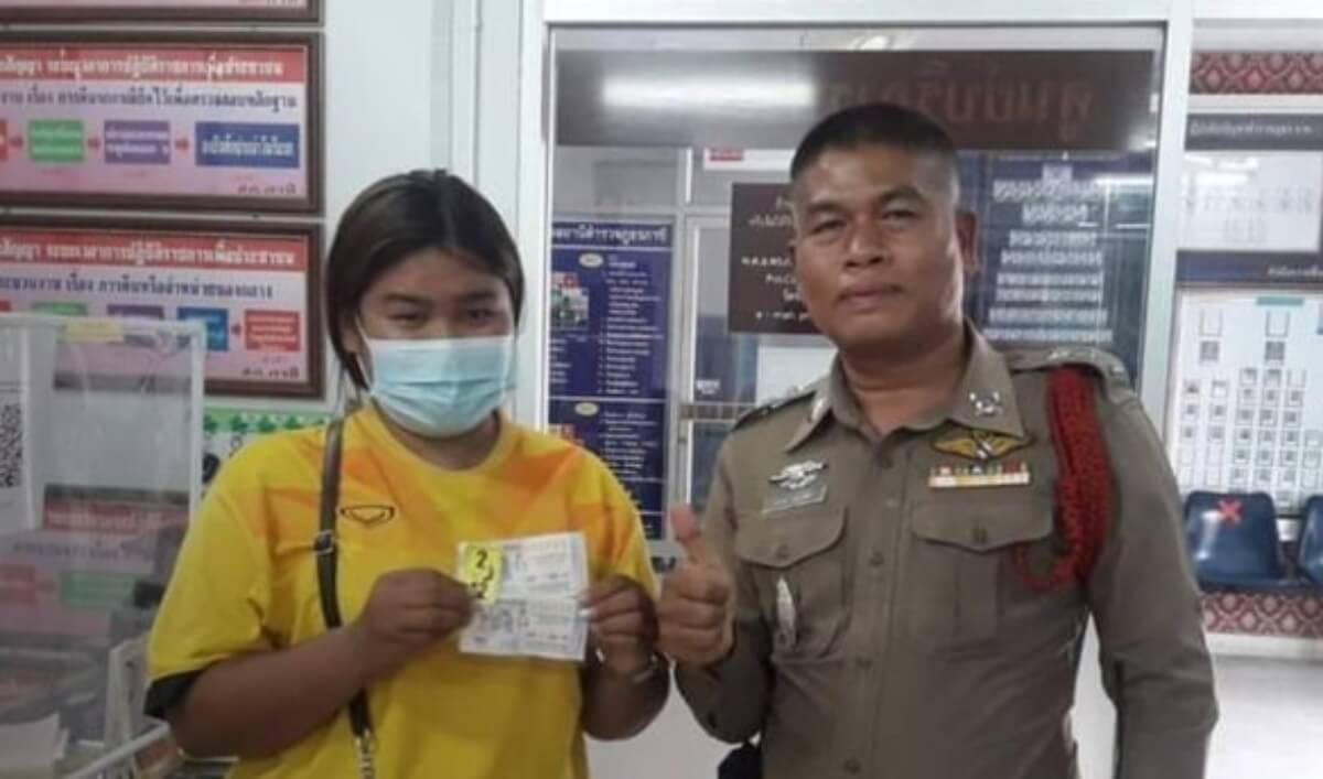 สาวคนงานก่อสร้างถือลอตเตอรี่ ยืนอยู่ข้างตำรวจ